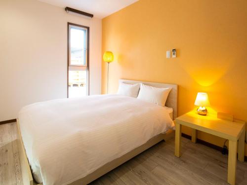 石垣岛巴布亚岛度假村的卧室配有一张白色的大床和一张桌子