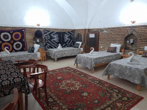 希瓦Caravan Sarai的一间设有四张床和砖墙的房间