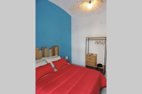 泰尔莫利Blue Sail Apartment的一间卧室设有红色的床和蓝色的墙壁