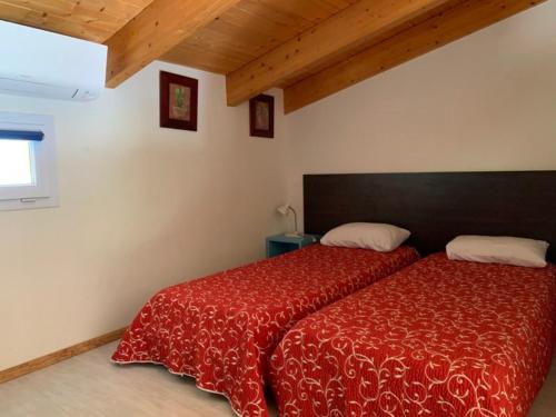 阿帕涅托Les Villas de Lava的一间卧室配有一张带红色棉被的床和窗户。