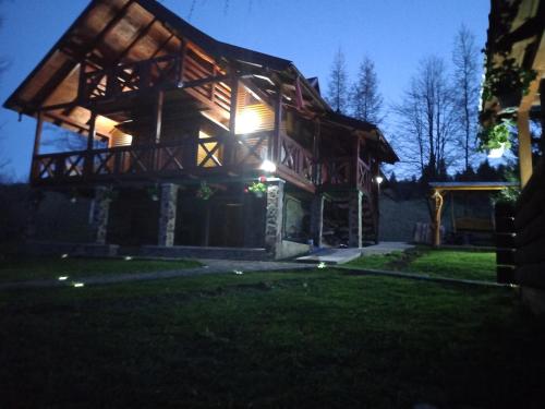 坎普朗莫道尼斯Cabana Aura Campulung Moldovenesc的夜晚的小木屋,灯光照亮