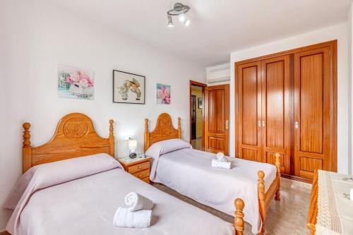 波连萨港Espectacular Apartamento的一间卧室设有两张床和木制橱柜。