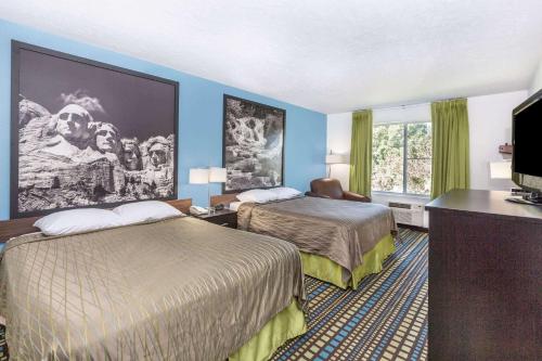 North Sioux CitySuper 8 by Wyndham North Sioux City的酒店客房设有两张床和一台平面电视。