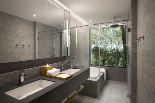 华欣dusitD2 Hua Hin的一间带水槽、浴缸和镜子的浴室