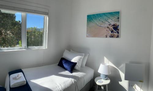科罗曼德镇Coromandel Town Harbourside Cottage Luxury Accommodation的白色的客房设有床和窗户。