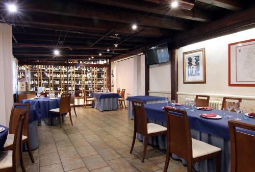 Montemayor de PilillaHOTEL RURAL LOS ABUELOS的一间用餐室,配有蓝色的桌椅和酒瓶架
