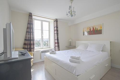 贝叶IKE'S Deluxe APARTMENT in Bayeux的一间卧室设有一张床、一台电视和一个窗口。