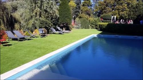 罗讷河畔沙斯LE DOMAINE DE GORNETON的一个带躺椅的蓝色游泳池以及草坪
