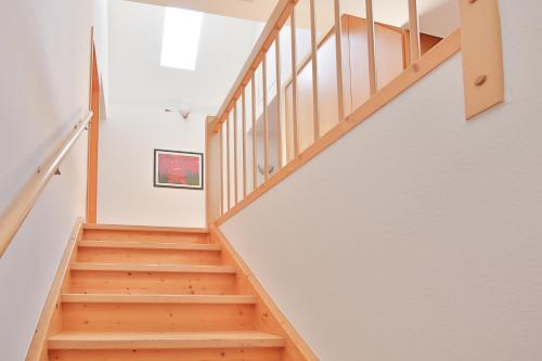 奥根Landgasthof zur Sonne的一座铺有木地板的房屋内的楼梯