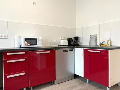 杜塞尔多夫Gerresheimer Republic的一间带红色橱柜和微波炉的厨房