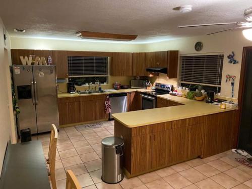 迈阿密Bella Stanza的厨房配有木制橱柜和不锈钢冰箱。