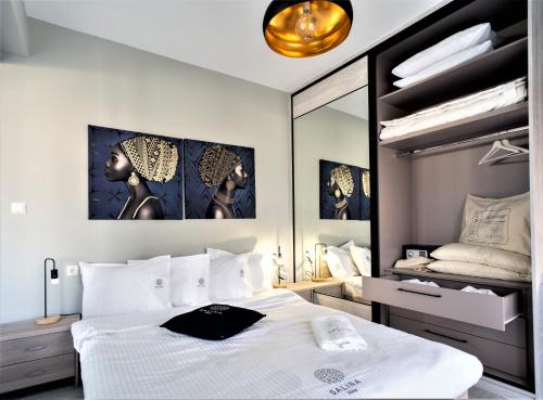 沃洛斯Salina Premium Residences Volos的卧室配有白色的床和镜子