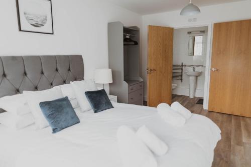 纽基Ocean 1- Sea View apartment, Fistral Beach Newquay的一间卧室配有白色的床和2个蓝色枕头