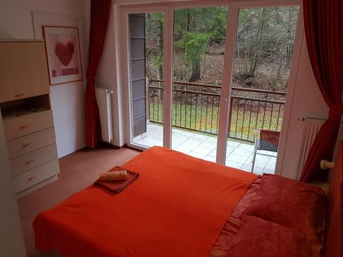 Rakitna拉奇特纳酒店的一间卧室配有橙色的床和大窗户