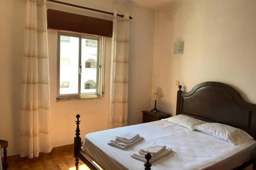 阿尔布费拉Casa d'Avó by RPG Properties的一间卧室配有床,窗户配有毛巾