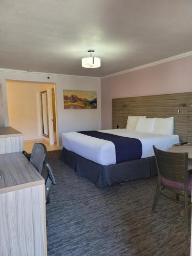 比蒂死谷酒店&房车公园的酒店客房设有一张大床和一张书桌。