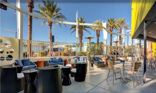 拉斯维加斯Bposhtels Las Vegas的庭院配有桌椅和棕榈树