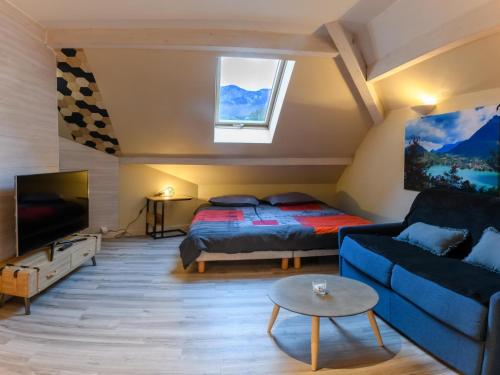 杜约特Au bord du lac d’Annecy, logement type Loft, dans résidence avec plage et ponton privée的客厅配有床和沙发