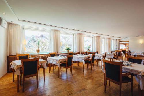 福尔巴赫Hotel am Mühlbach的用餐室设有桌椅和窗户。