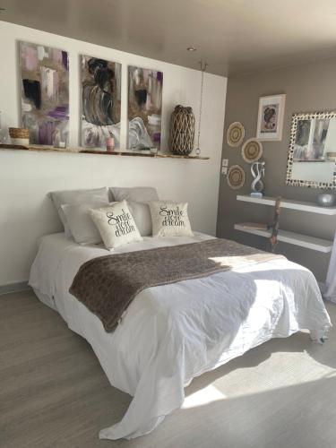 奥比格诺克La Salamandre de l Olivier - le Mimosa的卧室配有一张带白色床单和枕头的大床。