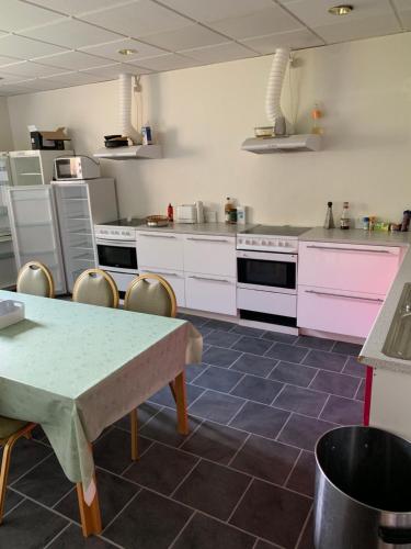 SkibbySkuldelev kro的厨房配有粉色电器和桌椅