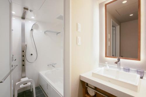 大阪Hotel Forza Osaka Namba的白色的浴室设有水槽和淋浴。