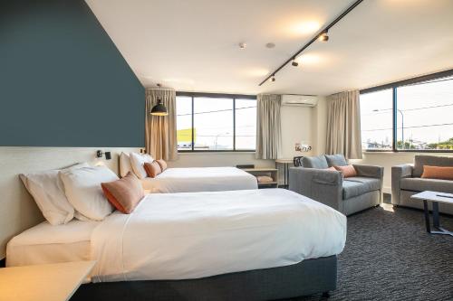 布里斯班查尔顿科纳奈特卡普酒店的酒店客房,设有两张床和一张沙发