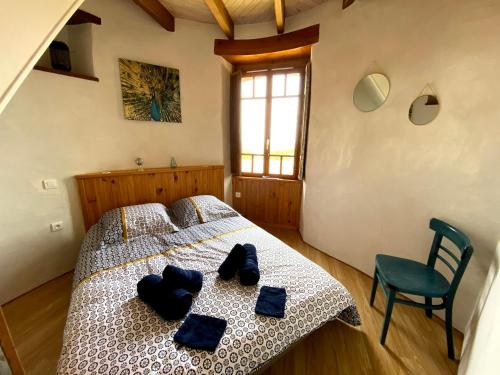 Saint-Georges-du-Puy-de-la-GardeLE MOULIN DES GARDES的一间卧室配有一张带蓝色枕头的床。