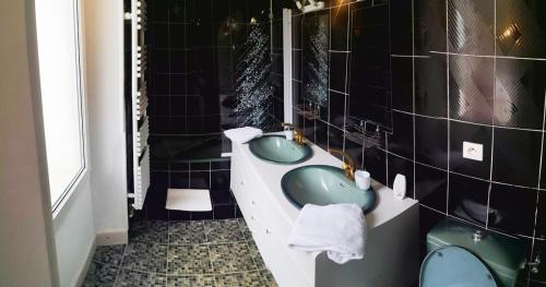 拉尔让蒂埃拉贝塞埃Icerock Hotel的浴室配有两个绿色水槽和一个浴缸。