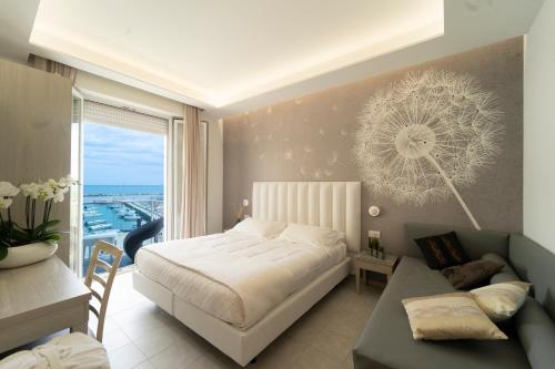 里米尼斯特拉多罗酒店的一间卧室配有一张床、一张书桌和一个窗户。