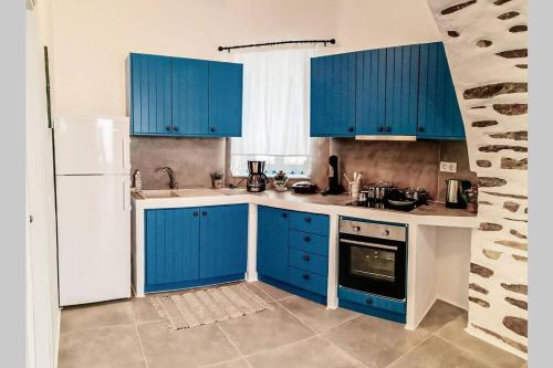 KóstosKostos House BLUE的厨房配有蓝色橱柜和白色冰箱