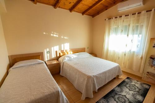伏罗拉VILA LLANO的一间卧室设有两张床和窗户。