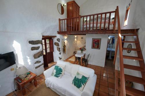 EreseCasita Pedro González的客厅设有白色沙发和楼梯。