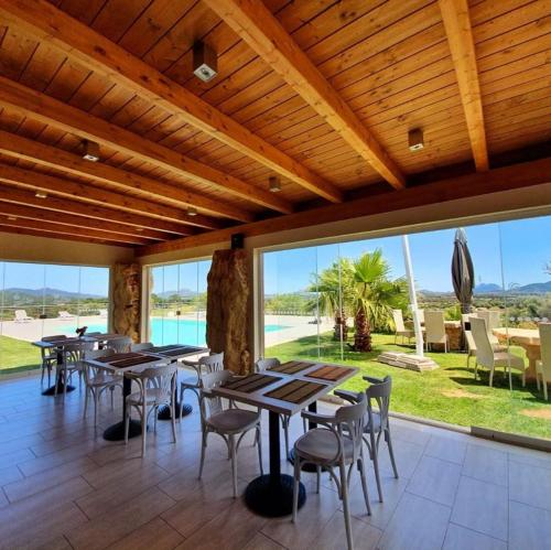 奥尔比亚Hotel Botanic Golf SaCuba的用餐室设有桌椅和窗户。