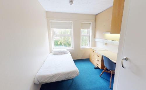 布莱顿霍夫Phoenix Halls的客房设有两张床、一张桌子和一个窗户。