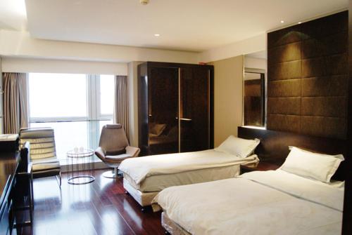 南京南京凯宾酒店公寓连锁新街口店的酒店客房,配有两张床和椅子