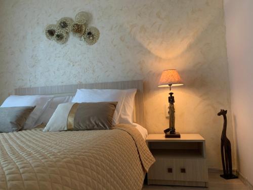 克卢日-纳波卡Maya Apartment的一间卧室配有一张床和一张桌子上的台灯