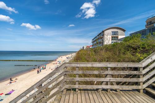 尤斯托尼莫斯基Na Klifie - Apartamenty KOMFORT, widok na morze, parking的从木板路欣赏海滩美景