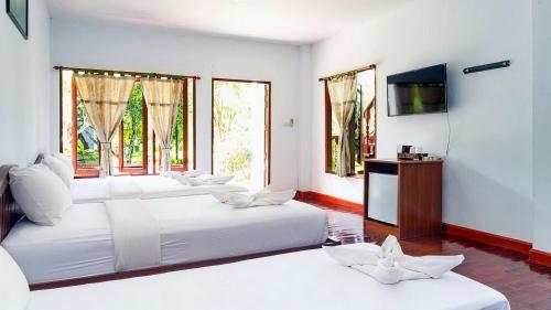 奥南海滩Doo Dee Boutique Resort by Swiss Chalet的客房设有三张床、一台电视和窗户。