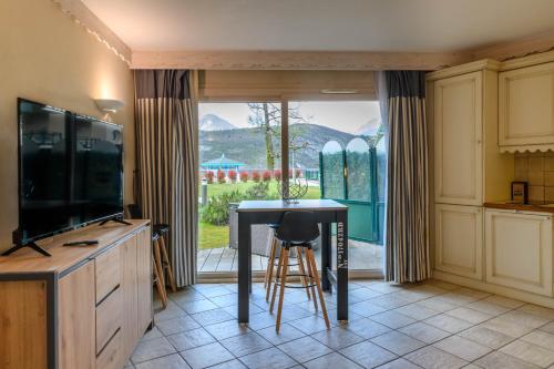 杜约特Rare : au bord du lac d’Annecy, cosy appartement en rez de jardin avec terrasse privative的厨房配有桌子、电视和窗户