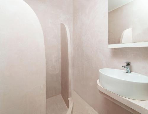苏卡雷斯Adani Hotel的浴室设有白色水槽和镜子