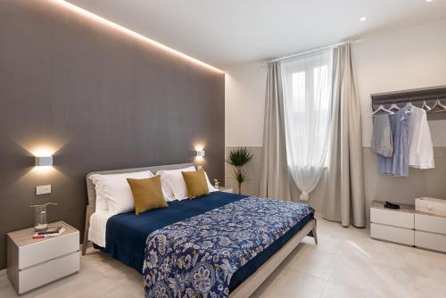 福洛尼卡Oltremare的一间卧室配有一张带蓝白色床单的大床