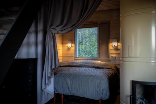 OrjakuHiiumaa Summerhouse的一间卧室设有一张床和一个窗口