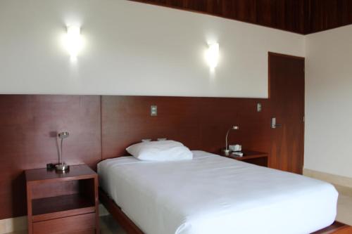 坎昆Hotel Casa Grande Cancun的卧室配有白色的床和2个床头柜