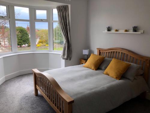 斯卡伯勒Acacia Breezes - Delightful Scarborough Semi的一间卧室配有一张带黄色枕头的床和一扇窗户