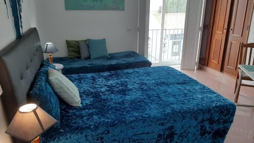 萨格里什Sagres Sunny Room的客厅配有蓝色的床和沙发