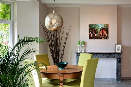 那慕尔里安乡村度假别墅酒店的一间带木桌和黄色椅子的用餐室