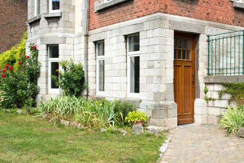 那慕尔里安乡村度假别墅酒店的砖砌的建筑,有棕色的门和院子
