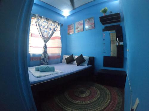 班塔延岛Casa Isabel Hostel的蓝色的客房设有一张带窗户的床