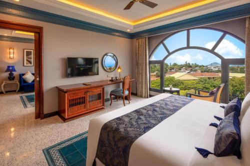 顺化Silk Path Grand Hue Hotel的一间卧室设有一张大床和一个大窗户